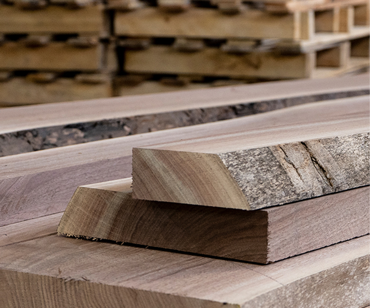 Rough-cut American hardwood boards—materials that drive hardwood furniture lead times for quality builds.